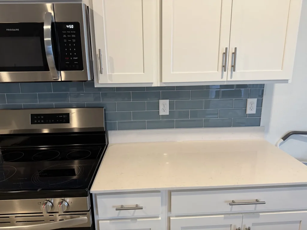 Glass subway tile backsplash behind range