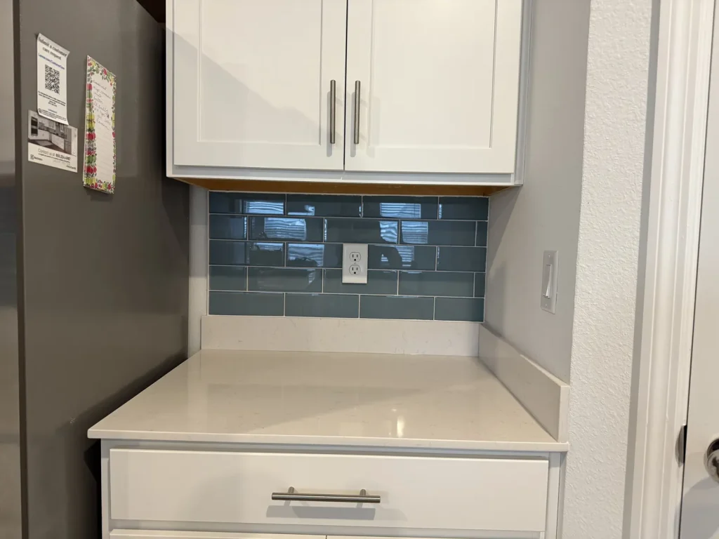 Glass tile backsplash with white quartz counter