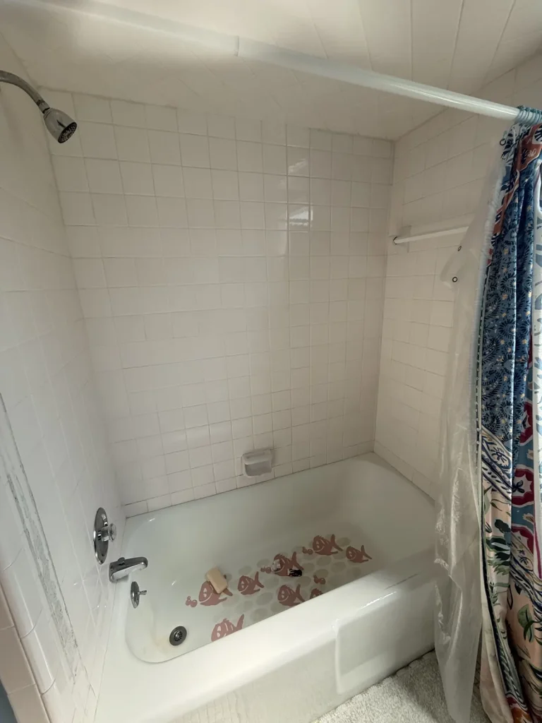 Before: dated white tile tub surround