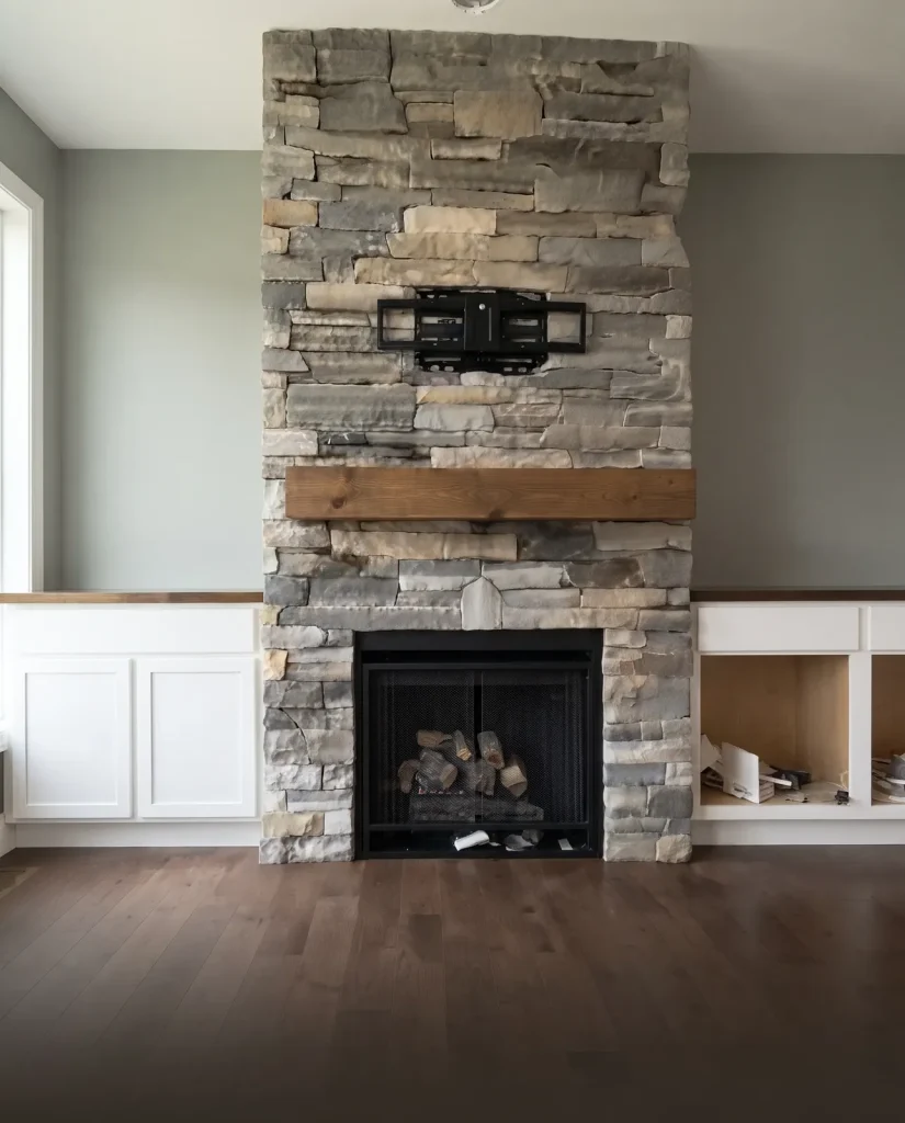 Floor-to-ceiling stacked stone fireplace surround with wood mantel