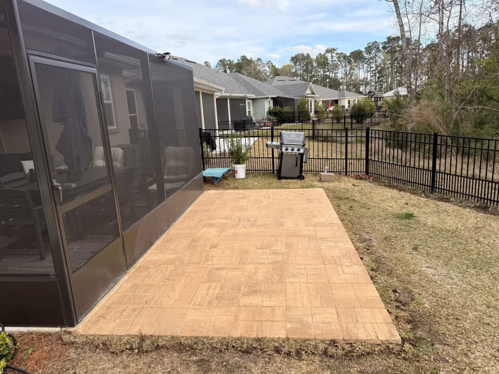 New paver patio beside a screened porch