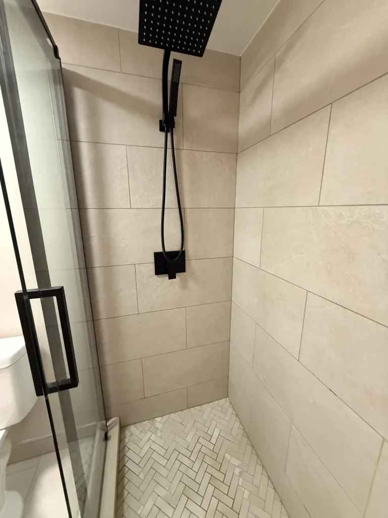 Large-format porcelain shower walls with matte black fixtures