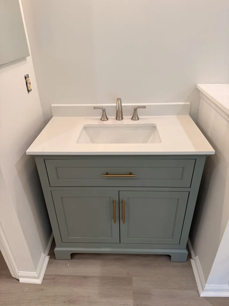 Sage green vanity installation with wood-look floor